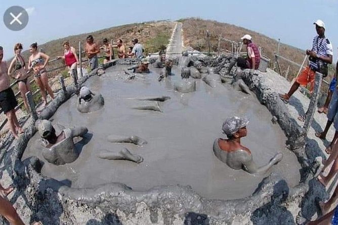 Personas sonriendo y cubiertas de lodo en el Volcán del Totumo